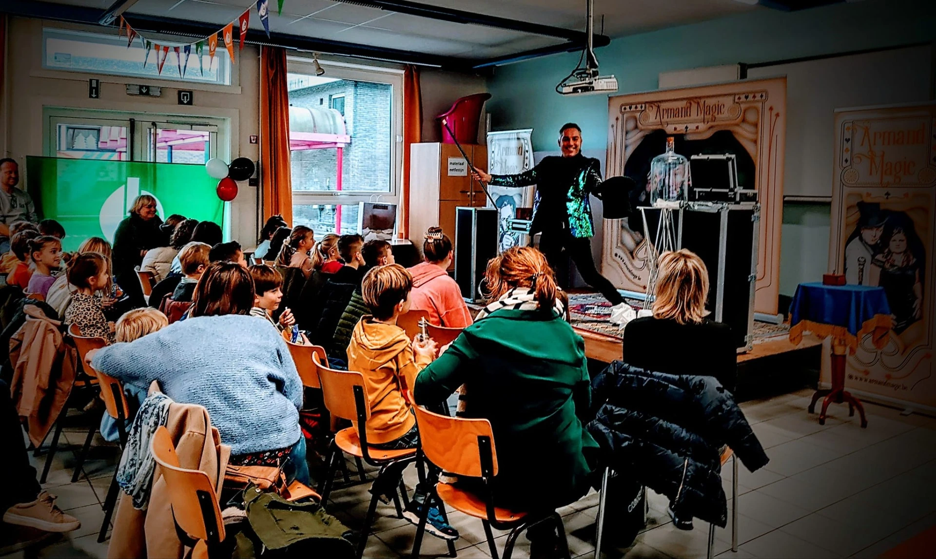 Armand Magic tijdens een interactieve goochelshow voor een zaal vol kinderen